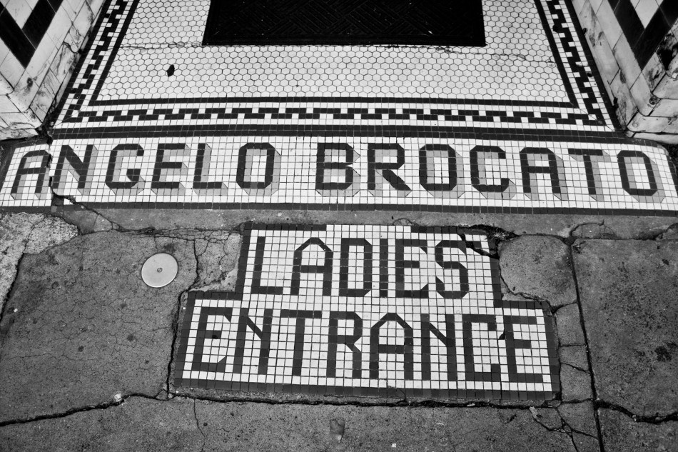An old mosaic sign outside the old location of the Angelo Brocato ice cream parlor embedded into the sidewalk in the French Quarter in New Orleans that reads "Angelo Brocato Ladies Entrance"