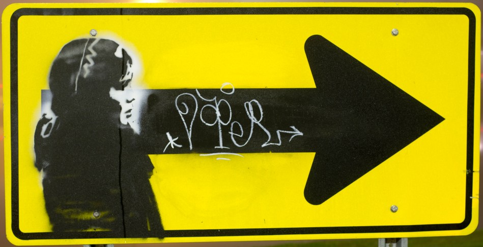 Graffiti of a woman on a traffic sign signed by the Graffiti artist named Doper