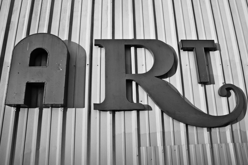 A large sign that reads ART hanging on a metal wall in the Bywater of New Orleans, LA