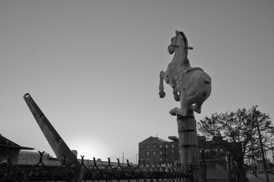 A children's play horse mounted on top of a fence post