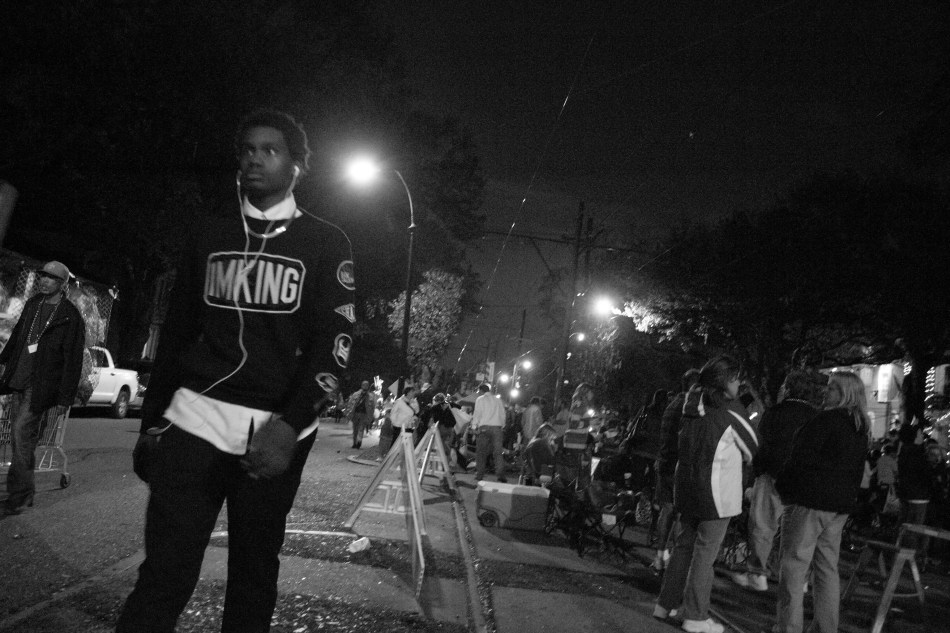 A man wearing a shirt with the words imking walking down St. Charles Avenue during Mardi Gras in New Orleans, LA on February 8, 2013