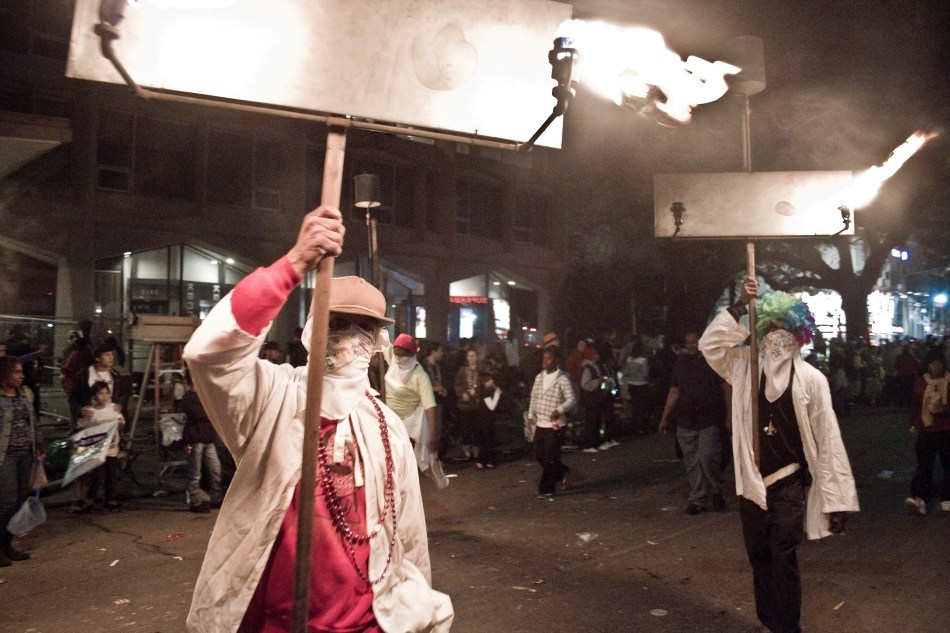 Two Flambeaux walk down St. Charles Avenue in a Mardi Gras parade in New Orleans, LA on February 8, 2013.