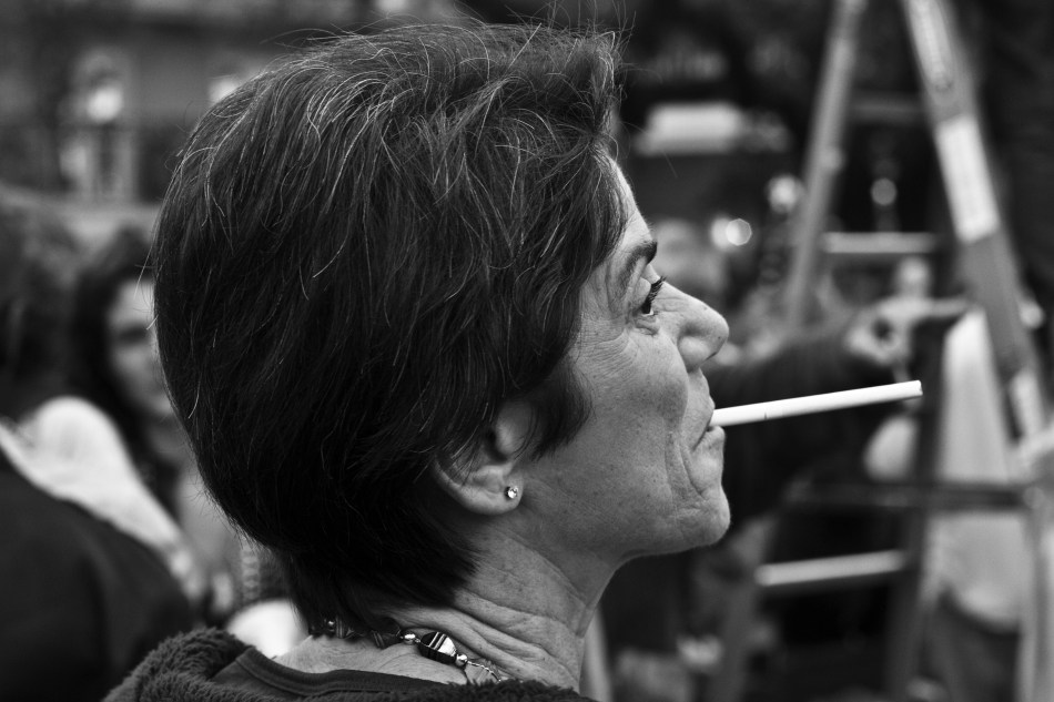 A woman smokes a cigarette at the Endymion Mardi Gras parade in New Orleans, LA