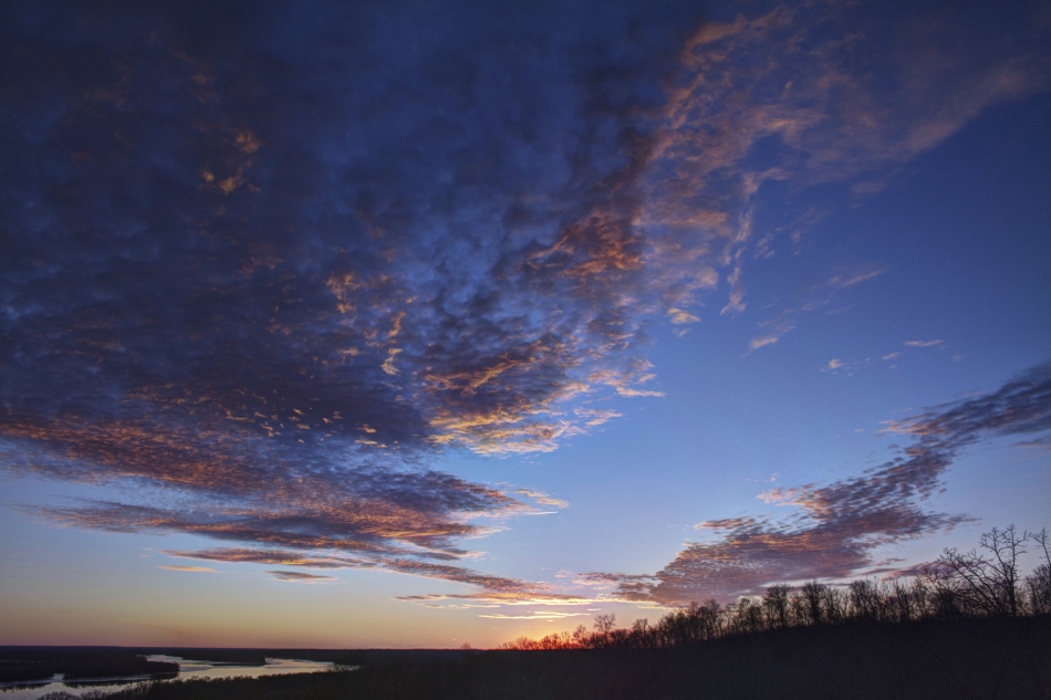 A high dynamic range image of the sunset on the horizon over the Illinois River in Grafton, Illinois.