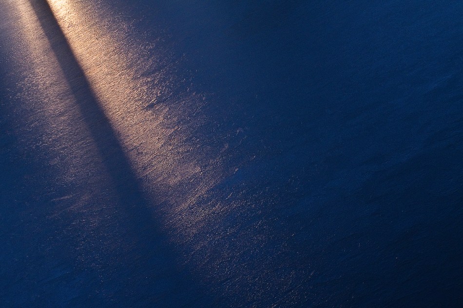 A beam of sunlight reflecting off of a sheet of ice in Willmore Park, St. Louis, MO