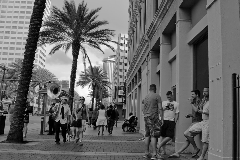 A black and white street photography image of people walking down Canal Street in New Orleans, LA