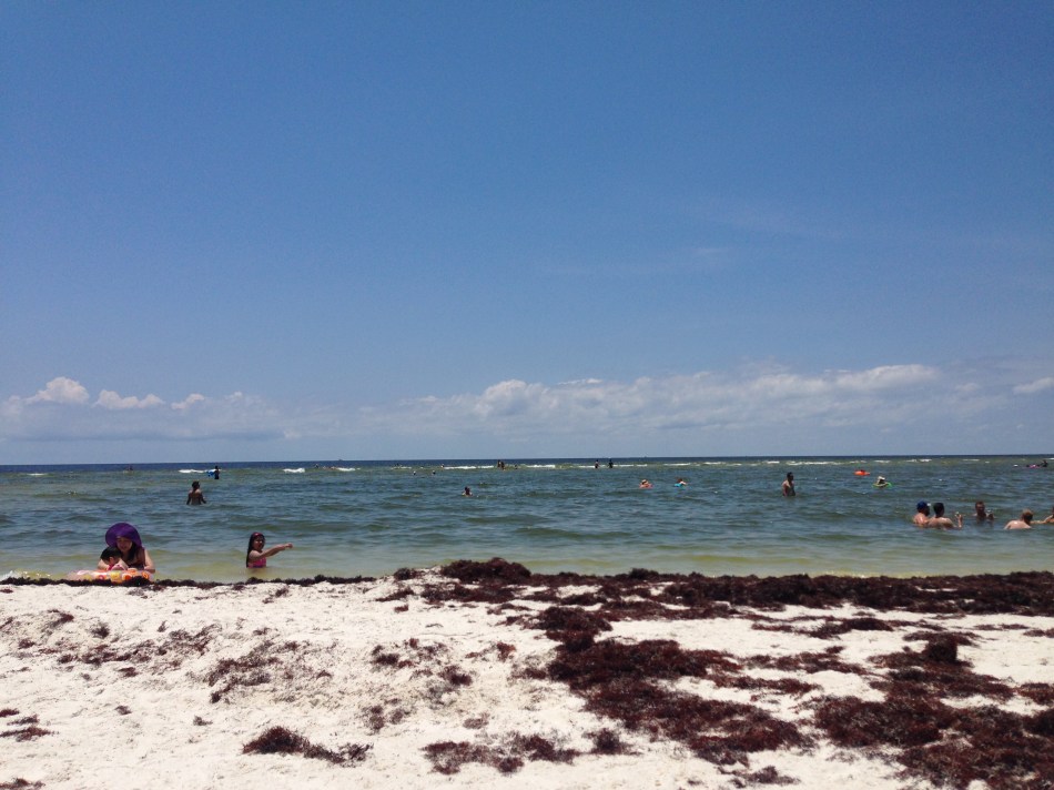 A view of swimmers, the Gulf of Mexico, and white sand at Ship Island off the Mississippi Gulf Coast near Gulfport, Mississippi